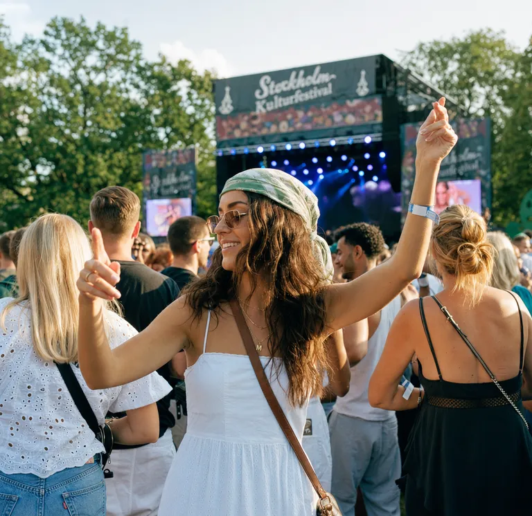 Människor dansar och firar tillsammans på svensk musikfestival utomhus